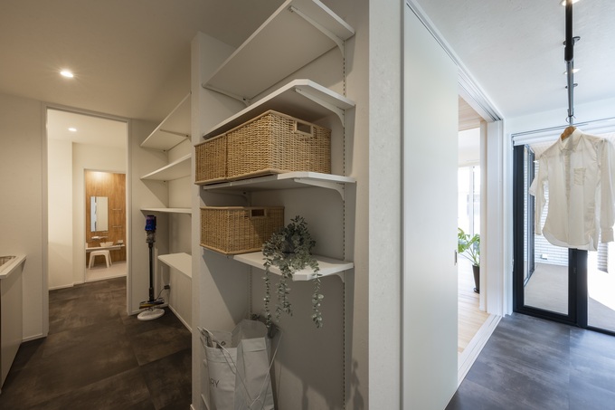 機能的に設計されたパントリー。棚には籠や小物が整理され、清潔感がある。隣接する部屋にスムーズにアクセスできる動線が魅力。