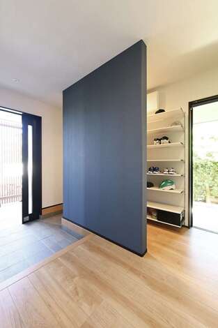 家族用の玄関を壁で仕切って靴棚を設けてあり、正面の玄関は常に美しくキープ。玄関ポーチにはガレージに面してFIX窓を設けてあり、玄関スペース全体に明るさと開放感をもたらしている