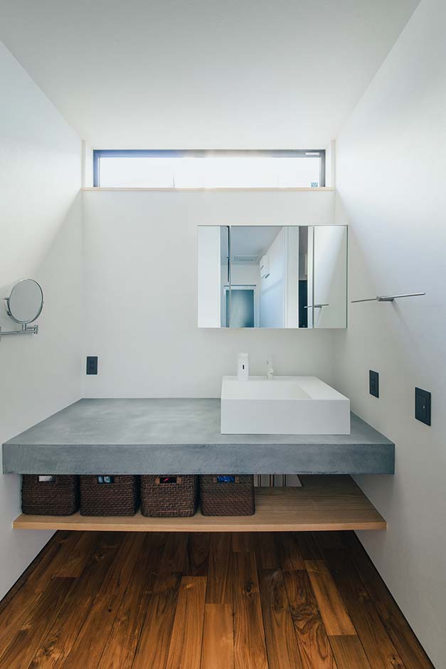 平屋建築ブルーハウス【デザイン住宅、建築家、平屋】洗面は脱衣スペースと分離して確保。造作洗面台の天板にユーロプラストを採用したことで、無機質でスタイリッシュな雰囲気に仕上がった