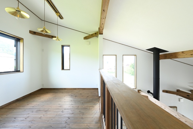 スキップフロアのエリア。手すりには木材を使用し、明るい照明で室内をスタイリッシュに演出
