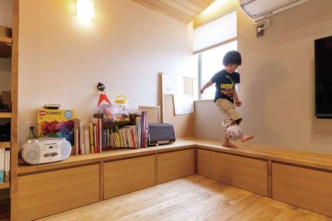 壁沿いに造作したベンチにもなるL字型収納でリビングはすっきり