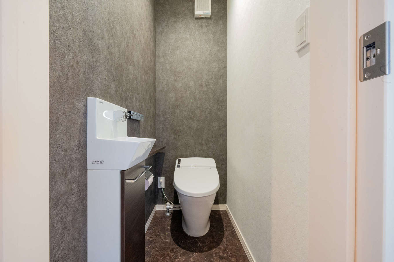 遠州鉄道 遠鉄ホーム【デザイン住宅、子育て、ペット】トイレはLDKのイメージに合わせて床と壁をグレーで統一し、素材感の違いでおしゃれを強調