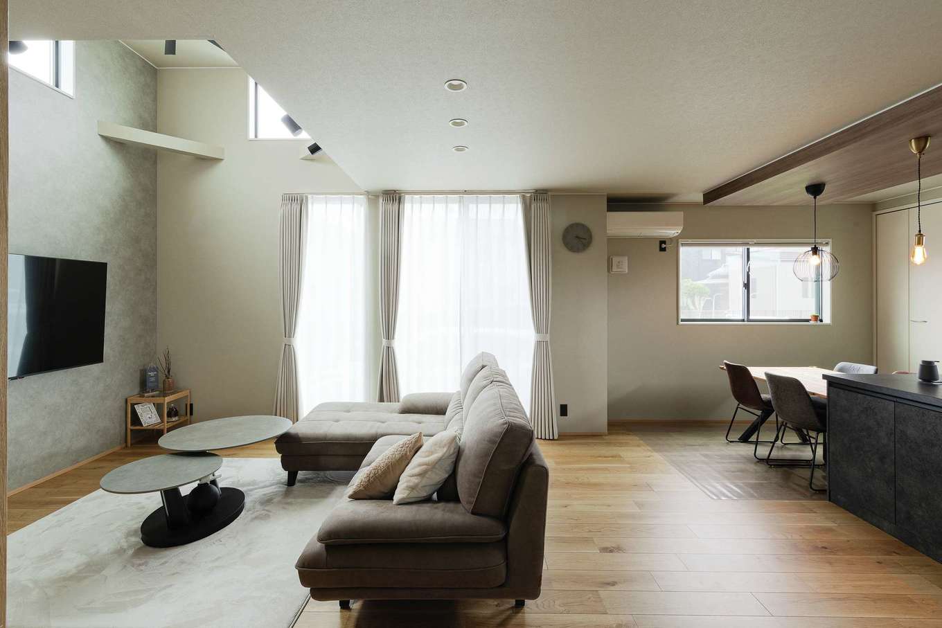 HAPPY HOUSE（山田工務店）【デザイン住宅、省エネ、インテリア】LDKは小上がりの畳スペースを含めれば22.5畳の広さ。一部を吹き抜けとし、天井までの高さの窓を採用することで、実際の面積以上の開放感とナチュラルな明るさで満たされている。大きな空間だが、優れた性能のおかげで、冬でもエアコン1台で快適に過ごせた