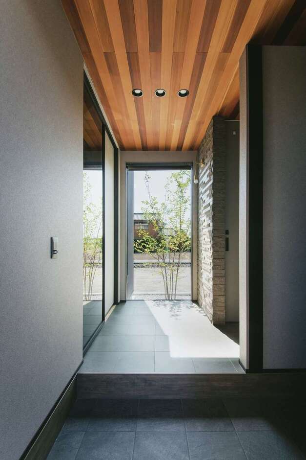 視線が正面奥のFIX窓に抜けていく、開放感あふれる玄関。坪庭の