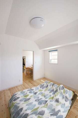 高さ制限があり天井高2.1mが限界だった主寝室。小屋裏を補強して船底天井にし、2.6mの高さを実現。圧迫感がなくなり広々