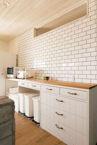 タイル張りのキッチンは色味をあわせてカウンターを用意。収納量はパントリーに任せ、キッチン回りはすっきり＆便利に。ゴミ箱の工夫など上総さんの女性目線がキラリ