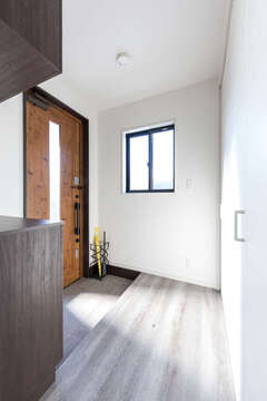 玄関ホールもシャビーシックに。ホールの壁は、床下収納も備えた大容量の収納に。たっぷりの可動棚で玄関周りとリビング収納を兼ねることができる