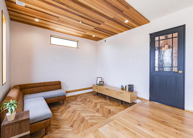 リビングは一段床を下げたピットスタイルを採用し、天井にレッドシダーを貼って空間をゆるやかに分けている。シンプルな箱型のLDKにメリハリが生まれて過ごしやすい