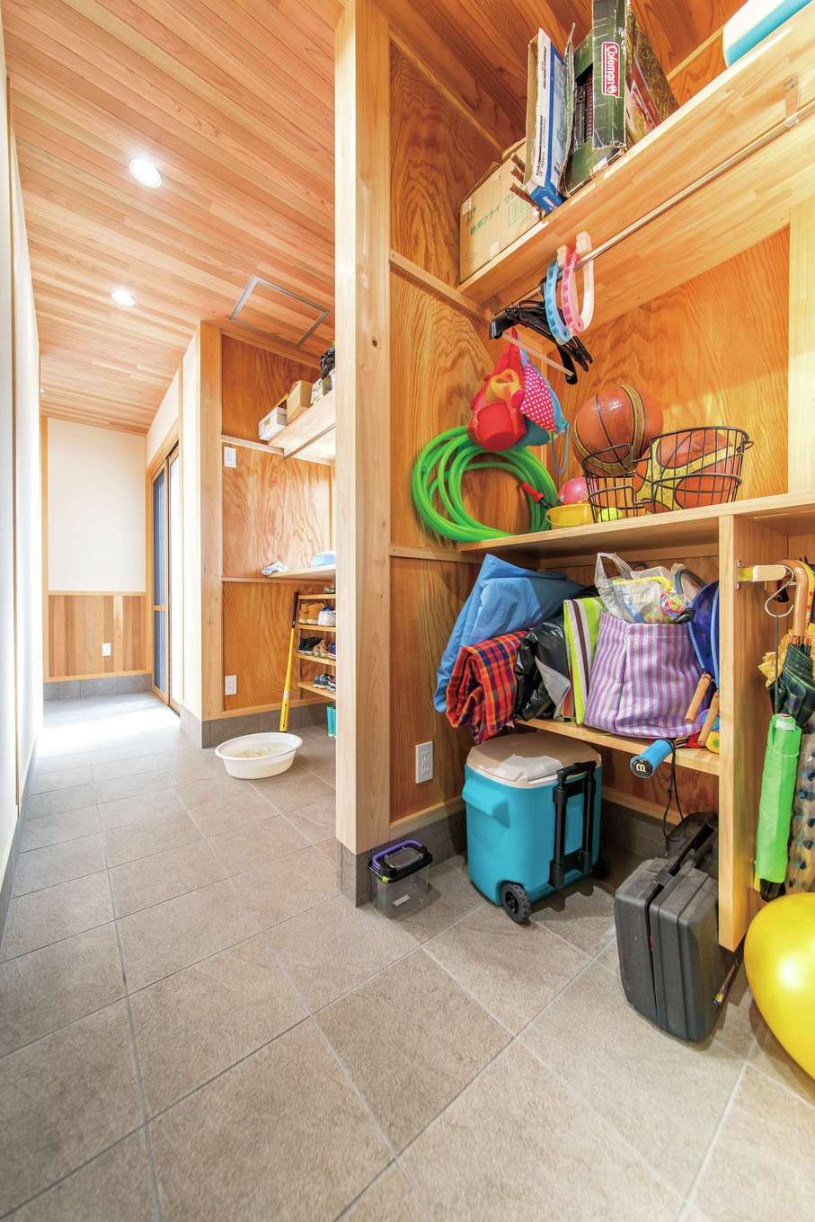 櫻 工務店【和風、自然素材、間取り】玄関を入って左側に位置する大きな土間空間。靴や上着など日常の玄関収納と、キャンプ・アウトドア用品を収納するスペースに分かれており、たっぷり収納できる