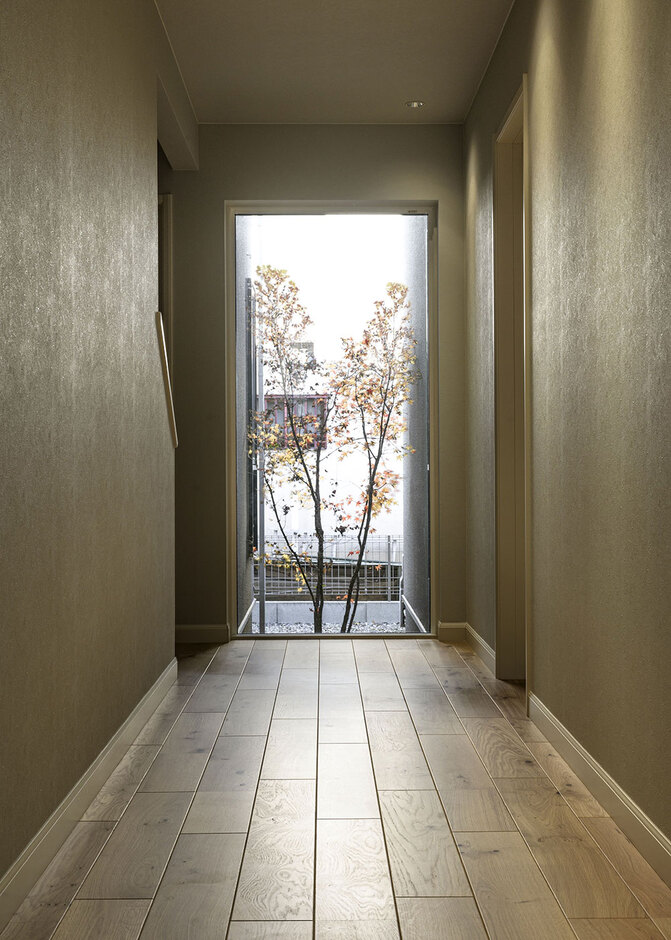 玄関先に見えるピクチャーウィンドー。坪庭のモミジの眺めが、まるで一