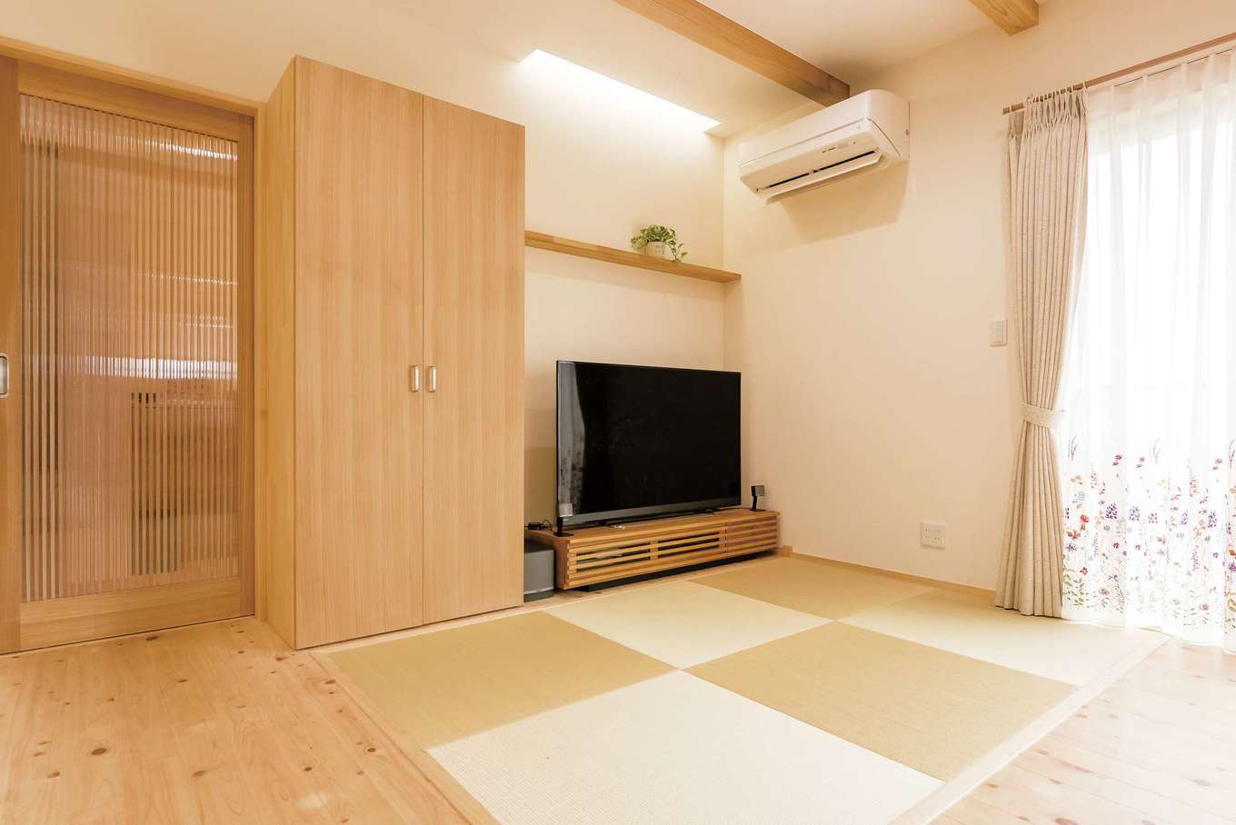 フジモクの家（富士木材）【子育て、自然素材、インテリア】ゴロンと横になってテレビを見られる畳スペース。リビング収納は保育園のバッグや通勤カバンを入れておくのに重宝しているそう。玄関に通じる引き戸は人気の『フジモク』オリジナル建具