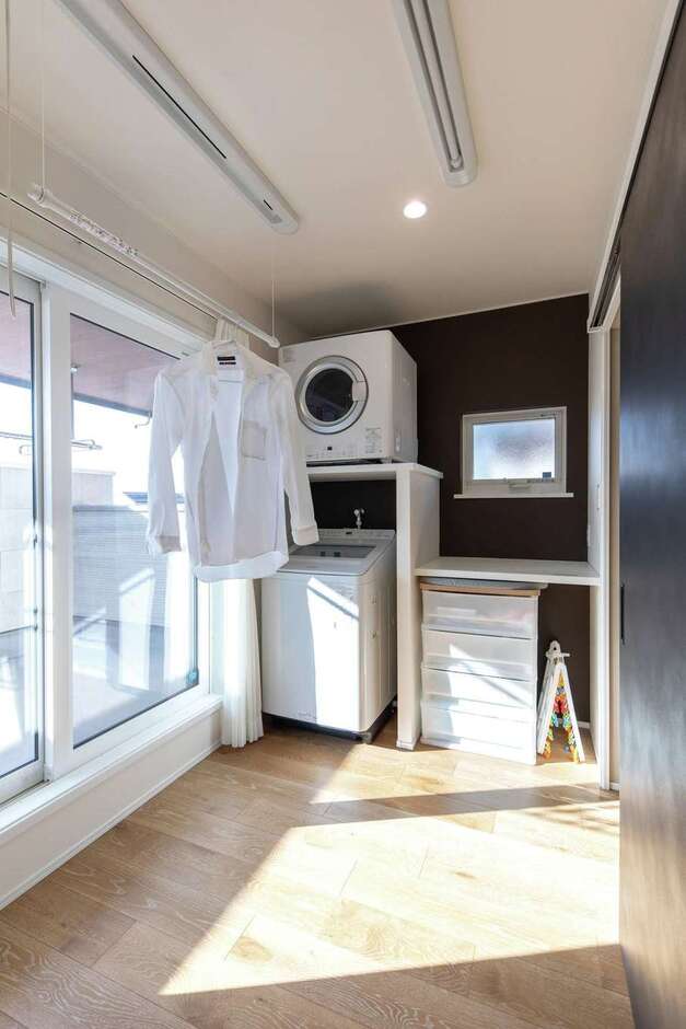 外干し用のバルコニーと室内干し用のポールで、たっぷりの洗濯物にも余裕で対応できるランドリールーム。ガス衣類乾燥機やアイロンがけなどの作業カウンターも