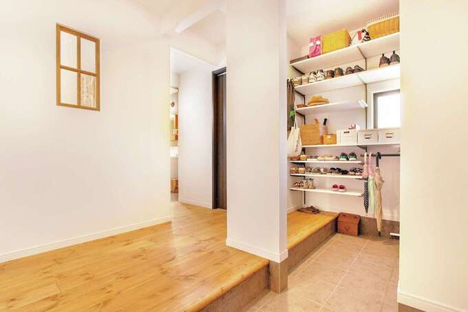 広々とした玄関収納は高さ可変の棚や傘掛けなどが用意され、収納力も機能性も想像以上だった。キッチン越しの室内窓は出発と帰宅の気配をやわらかく伝える