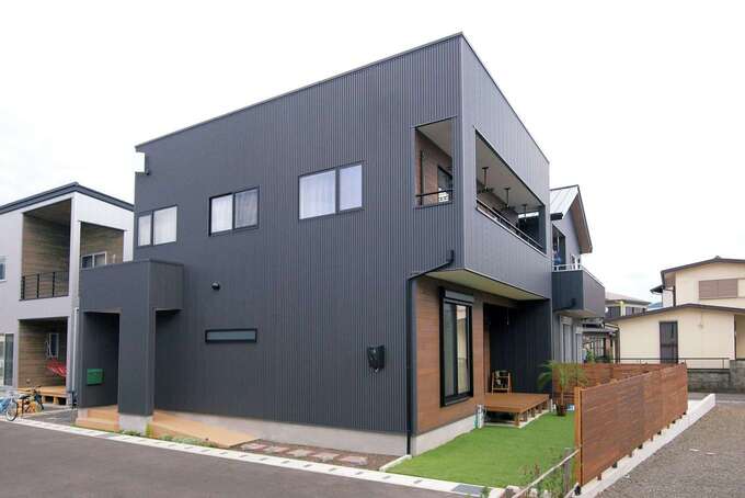 黒いガルバリウムを用いた外観。外構は家族が休日にDIY。ウッドフェンスは子ども達も一緒に塗装をした