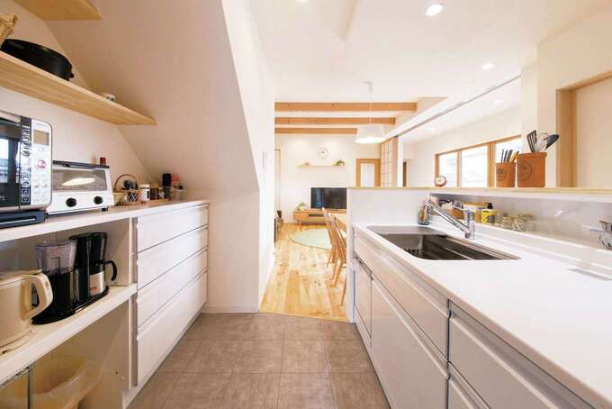 空間を効率的に利用した、使い勝手の良いキッチン。階段下スペース部分に背面収納を設けている