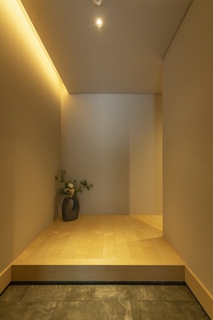 壁面に沿う間接照明がスタイリッシュな印象を与える玄関。シンプルなデザインが素材感を引き立てている