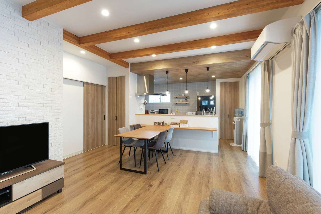 小玉建設【デザイン住宅、子育て、間取り】現しの梁が大らかな空間のアクセント。テレビ背後の壁には調湿＆消臭性に優れるエコカラットを採用