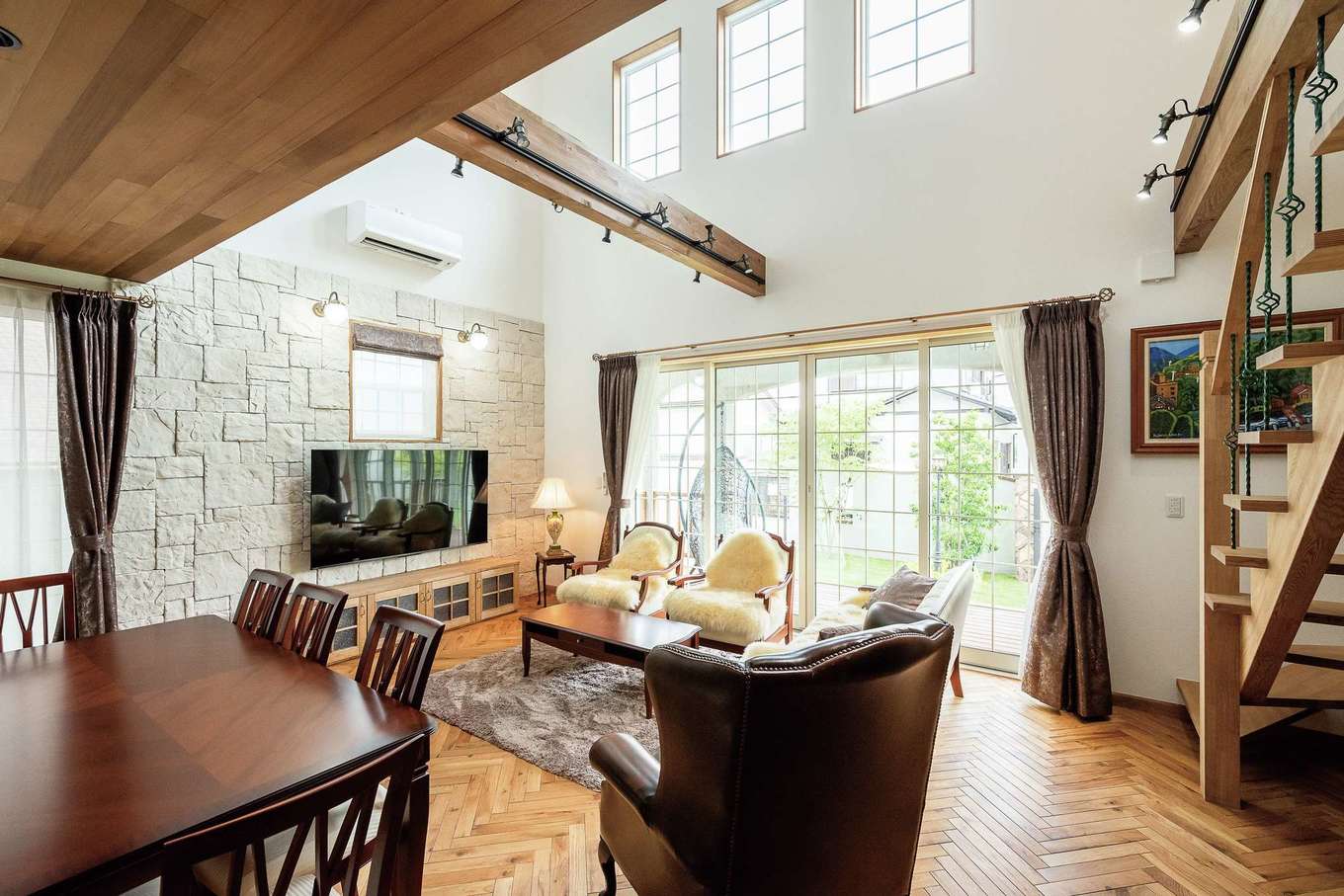 富士ホームズデザイン【デザイン住宅、自然素材、高級住宅】ヘリンボーン張りのオークと珪藻土に包まれるLDK。テレビ背後の石張りの壁が上質感をプラス。上総さんセレクトのオーセンティックな家具もマッチ