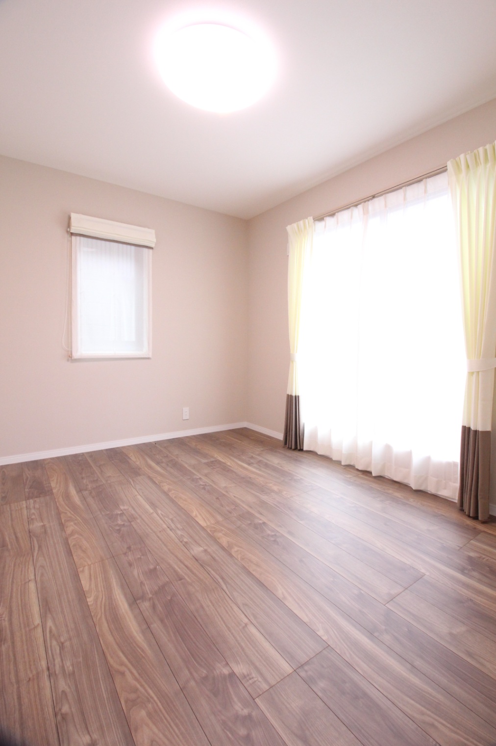 小野田産業～designers house project～｜明るい自然光が差し込む居室。優しい色合いのフローリングと壁が、落ち着いた雰囲気を演出している。
