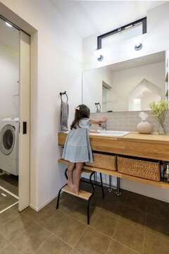 洗面室と脱衣室を分けたことで、誰かが入浴中でも洗面や歯磨きができて便利。造作の洗面台、ワイドな鏡は奥さまのお気に入り