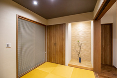 黒い天井とダークブラウンの建具で、落ち着ける雰囲気を演出。
表面をウェーブ加工した無垢の杉板を壁面に設え、かっちりとした印象も加えました。