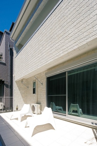 白いテラスはリビングの延長として部屋を広く見せる効果大。外でホットプレートが使えるようにコンセントを設置してある