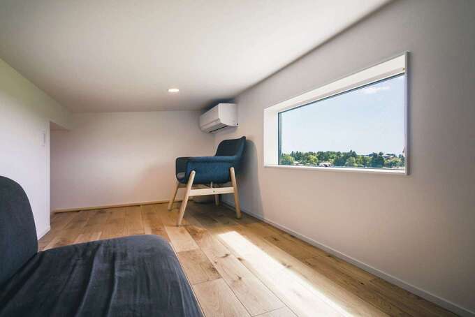 横長に壁を大きく切り取ったピクチャーウインドーが印象的なロフト。周囲の緑の風景を眺めながらゆったりくつろげるスペースは、セカンドリビングとして活躍している