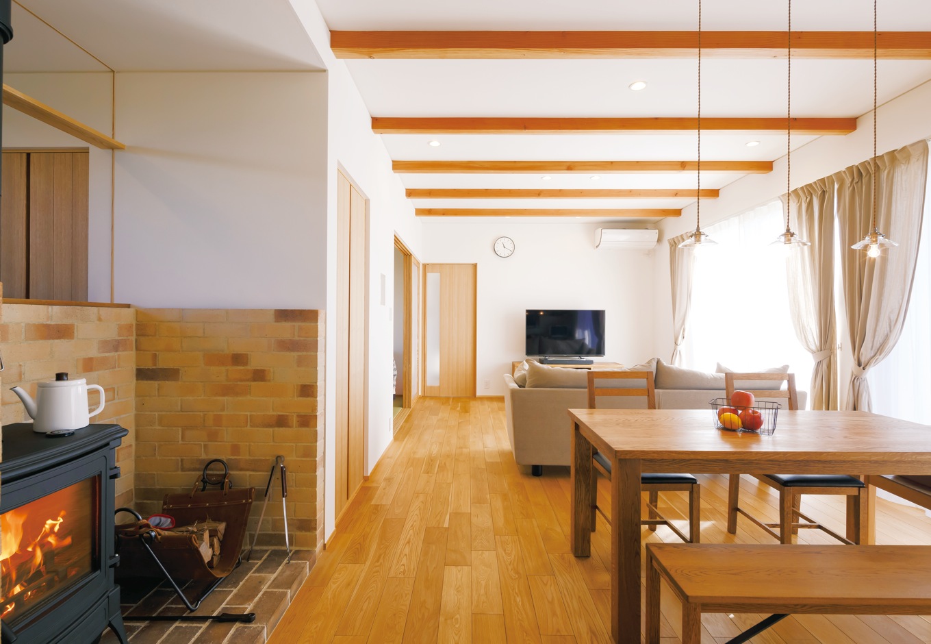 神谷綜合建設 カミヤの家【自然素材、間取り、インテリア】薪ストーブのあるダイニング。冬はこれ1台で2階の隅々まで暖まる。薪ストーブを囲むレン ガは床面を濃い色合いに、壁面を薄い色合いにしてグラデーションをつけアクセントに