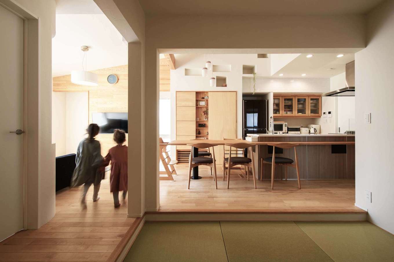 平屋建築ブルーハウス【デザイン住宅、子育て、平屋】玄関を上がると正面に和室があり、その先にはLDKが広がる。塗り壁（オンザウォール）とメープルの無垢床があたたかみを感じさせ、室内にほんのりと漂う木の香りに癒される。キッチンを中心に水回り、和室、リビングを回遊できる動線を確保したことで、家事ラクと暮らしやすさが実現