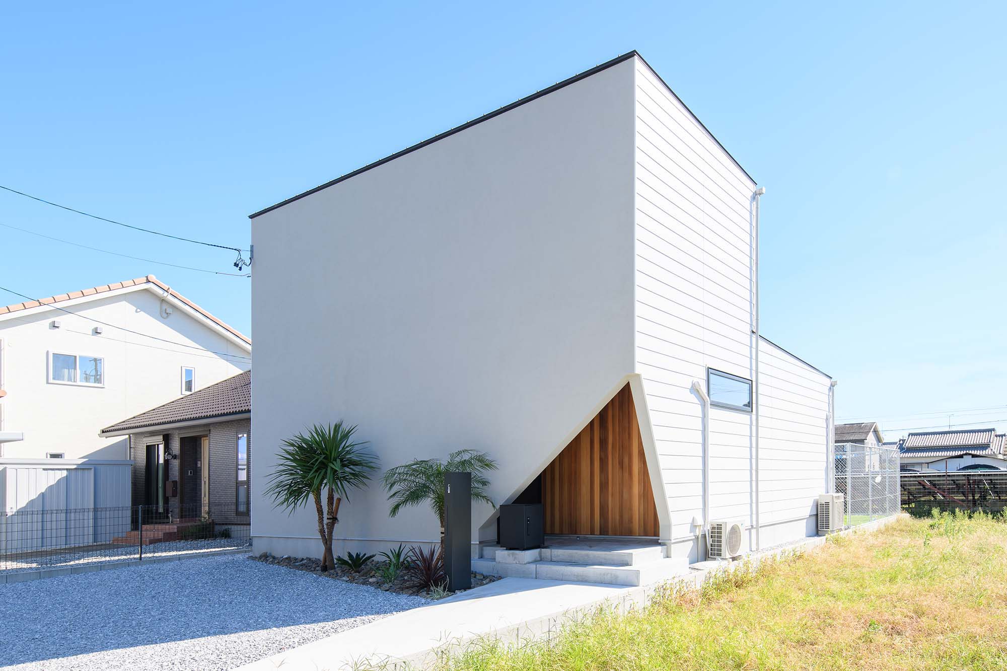 平屋建築ブルーハウス【デザイン住宅、間取り、建築家】淡いグレーの塗り壁と白のガルバリウムに木を合わせた、スタイリッシュな外観