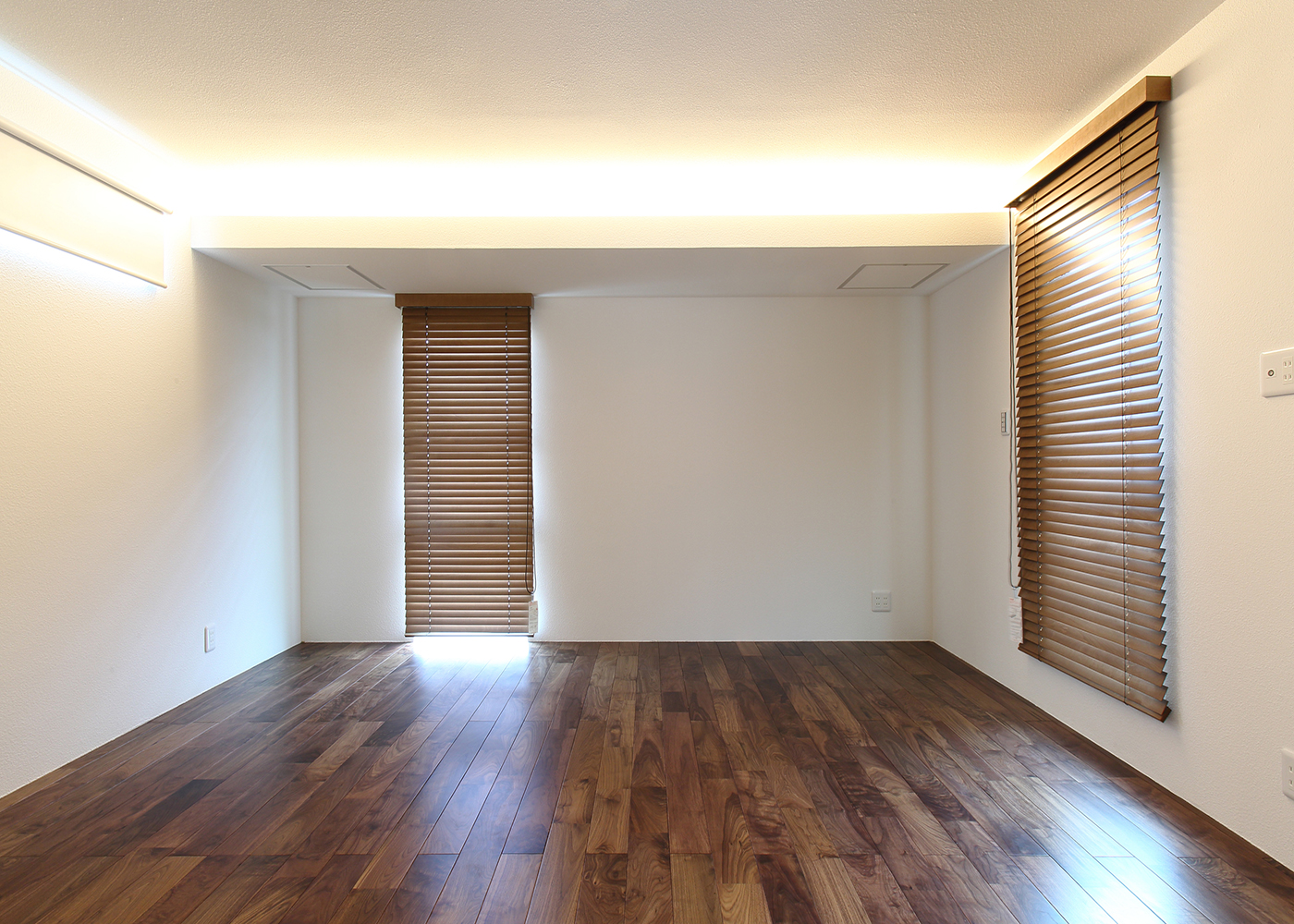 丸昇彦坂建設【デザイン住宅、間取り、ガレージ】寝室は、間接照明の光が柔らかく落ち、木調の床とブラインドの配色が部屋に暖かみを与える