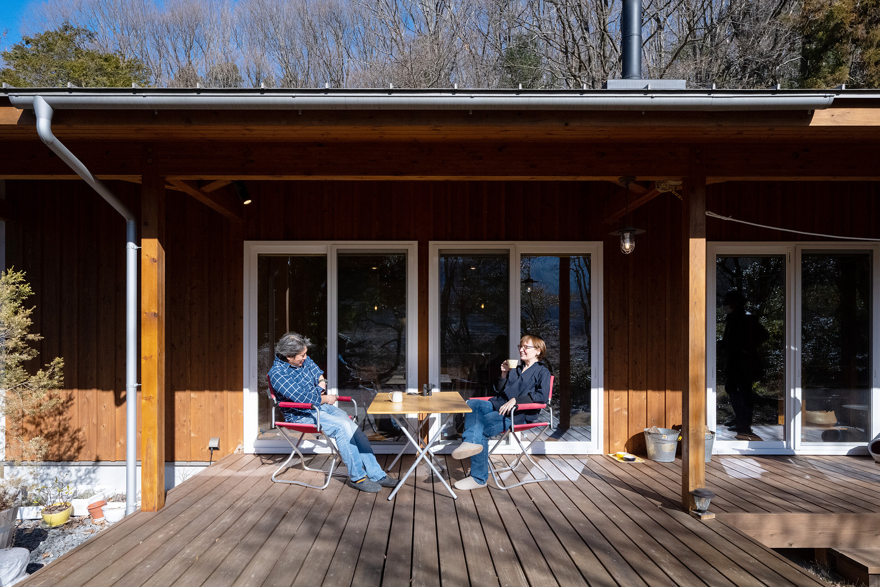 ネクストハウスデザイン｜自然と調和したウッドデッキで、リラックスしたひとときを楽しむ。大きな窓から光が差し込み、心地よい空間となっている。