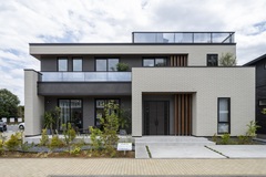 シンプルで洗練された二階建て住宅の外観。新しいデザインと自然と調和する植栽が心地良さを与えている。