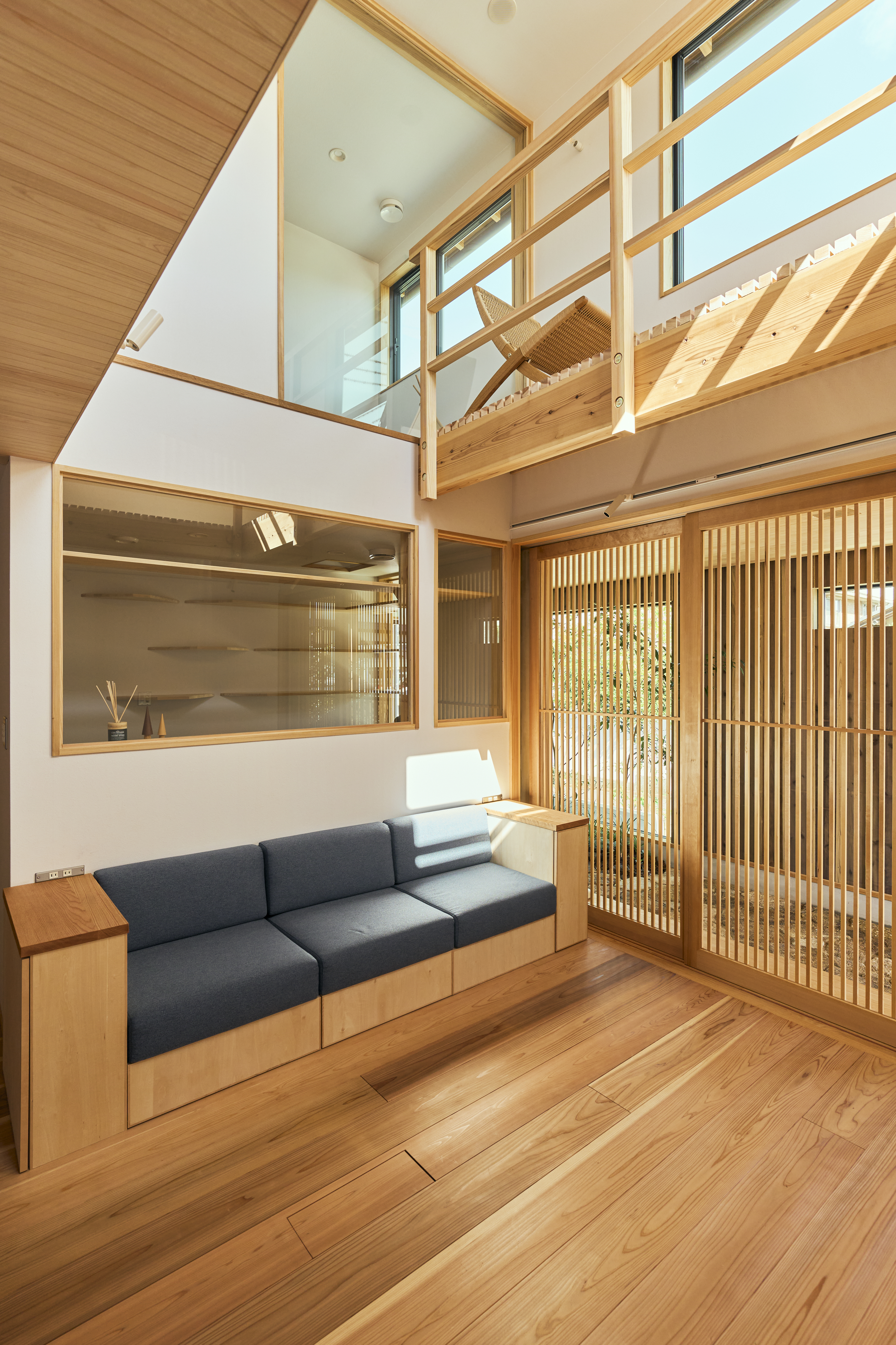 KEN建築工房｜木の温もりが感じられる明るいLDKスペース。吹き抜けからの自然光が心地よく、シンプルで機能的なデザインが魅力的。高い天井が解放感を演出しています。