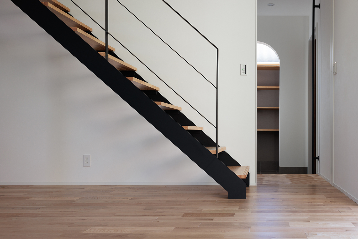 tact design firm【デザイン住宅、子育て、間取り】モダンなデザインのスケルトンのリビング階段。黒い手すりがアクセントとなり、空間に開放感とスタイリッシュさをプラスしている