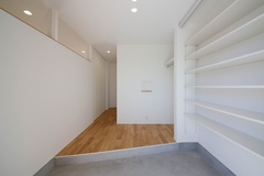 框を斜めにカットすることで幅をより広く確保し、家族が並んで靴を履ける玄関となっています。正面の壁には小さなニッチを施してあります。