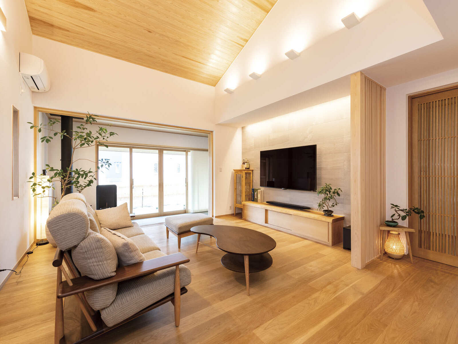 広和木材｜天井が高く、開放的なリビング。照明とインテリアが調和し、くつろげる空間に仕上がっている。