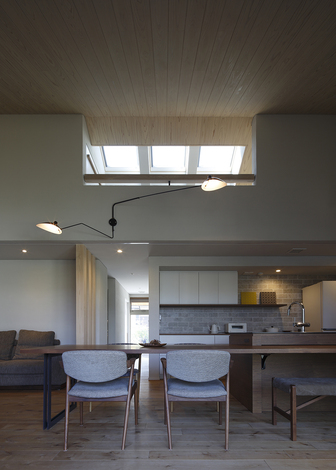 昼間は天窓からの採光、夜にはウォールライト・ダウンライトがLDKを明るく照らす