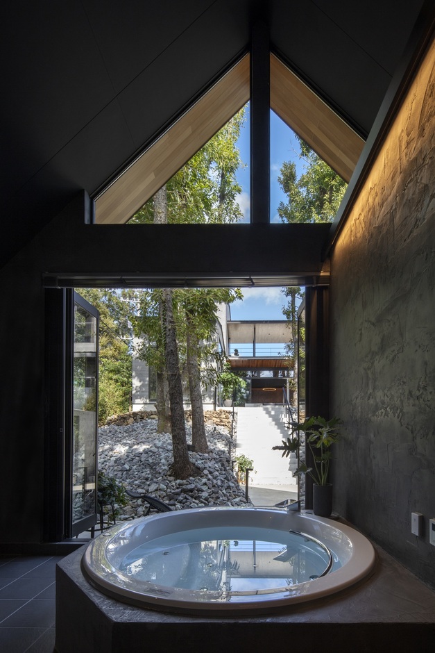 大きな窓から自然光が差し込むバスルーム。外の緑を眺めながらリラックスした時間を過ごせる、一日の疲れを癒す特別な空間である。