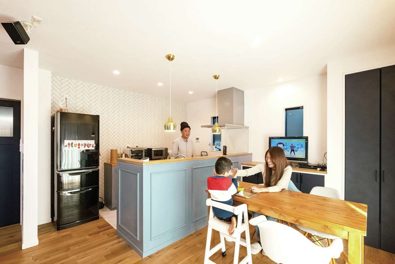 三和建設【デザイン住宅、子育て、間取り】ブルーのカウンターを造作したキッチン。ゴールドのペンダントライトが華やぎを添える