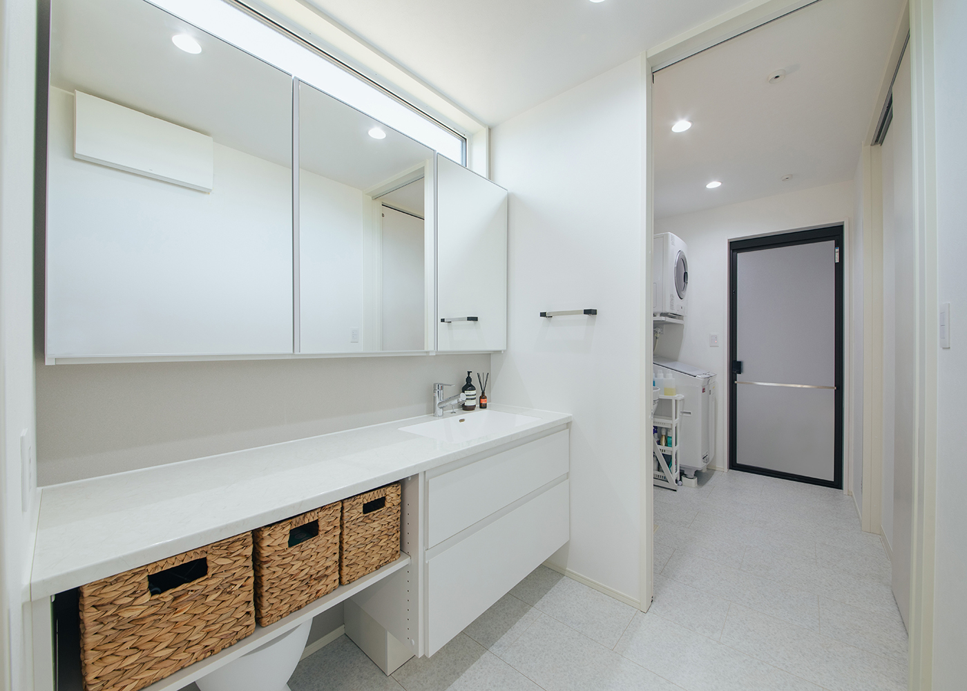 アイ工務店【子育て、間取り、平屋】キッチンから数歩で行ける洗面室。脱衣室と分けたことで、誰かが入浴中でも自由に利用することができる。メイクアップもできるようカウンターと鏡を広くとった