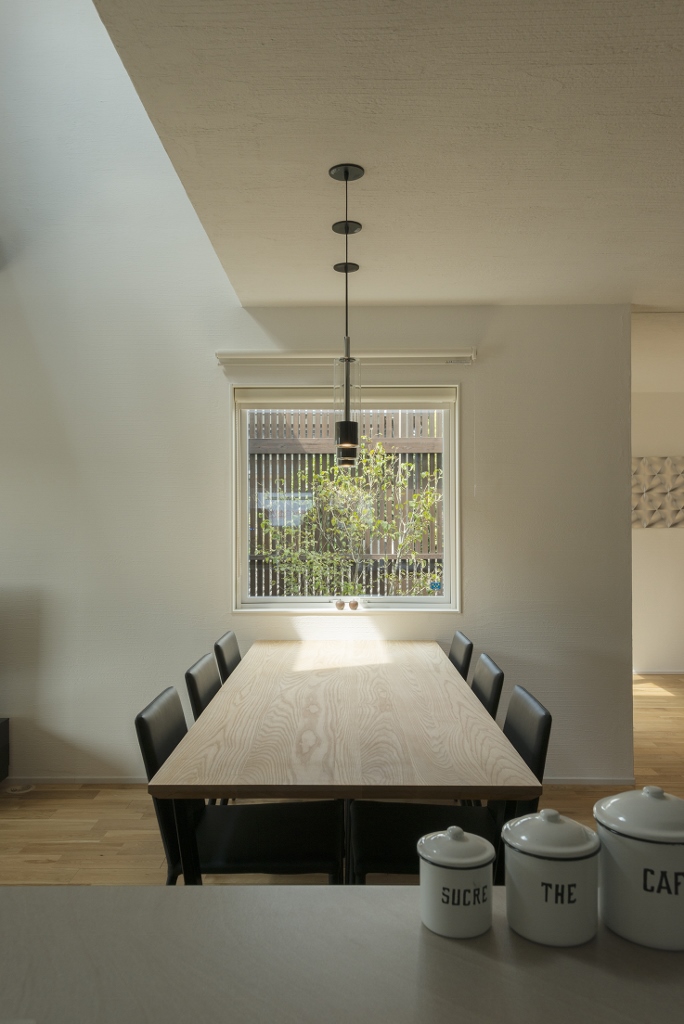 SEIEN ARCHITECT【デザイン住宅、インテリア、建築家】キッチンとダイニングの正面に四角の窓があり、まるで絵画のように空や緑が映りこむ
