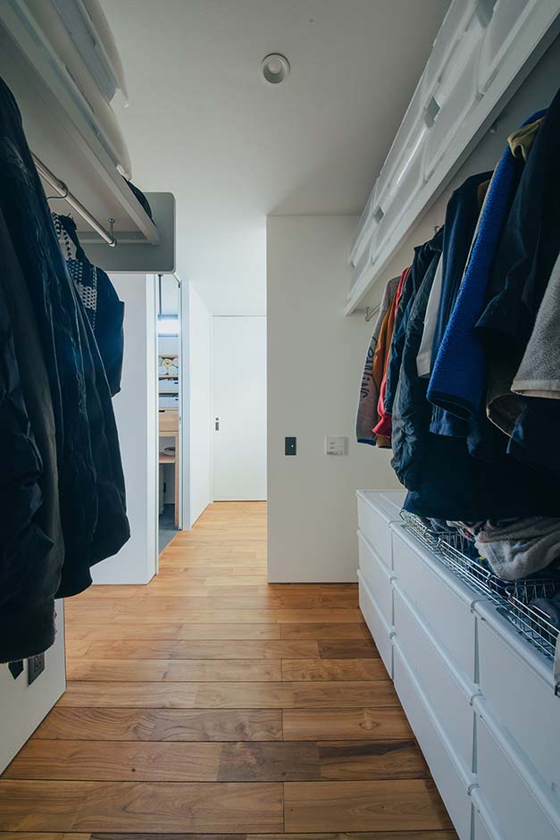 平屋建築ブルーハウス【デザイン住宅、建築家、平屋】3畳のファミリークローゼット。ハンガーパイプの下にボックスを置いたり、枕棚の上にも置いたりと十分に収納できる