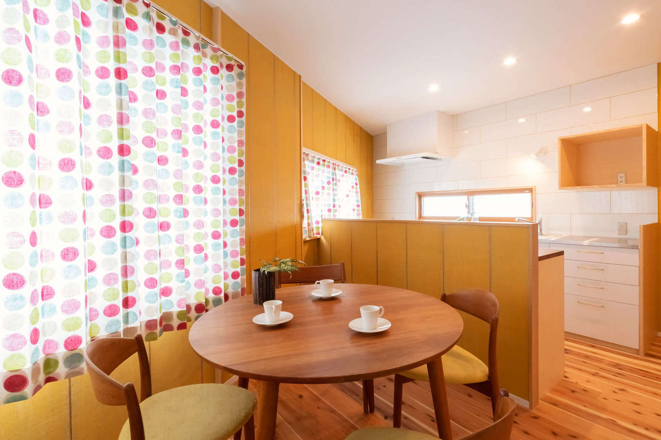 ALAIN（アラン）｜スギ板張りの床に黄色い壁を組み合わせたダイニングスペース。かわいらしい空間に丸テーブルがよく似合う。好きな家具、好きな色、好きな柄に囲まれた空間が、日々の暮らしにときめきを与えてくれる