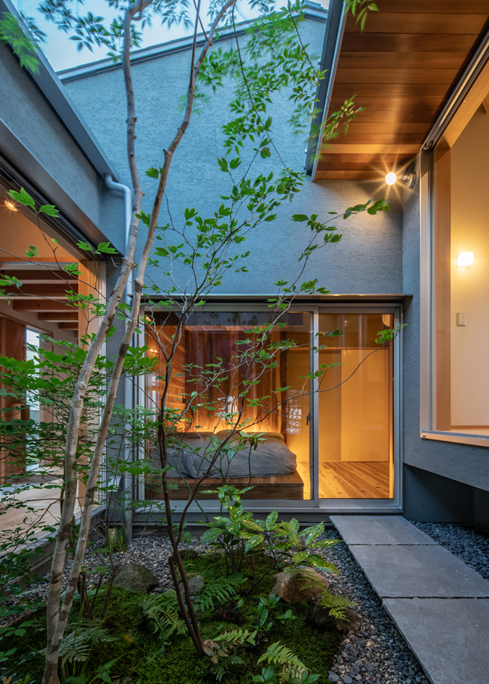 m+h（エムアンドエイチ）建築設計スタジオ【自然素材、建築家、平屋】屋外の中庭を通って主寝室へ向かうという独特な動線。ご主人の仕事場からもアクセスできる。右側に見えるスキップフロアは子ども部屋