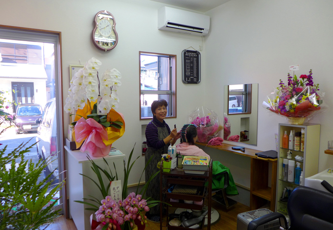 お母様が長年営んできた『パーマハウス・ライト』さん。お祝いの花に囲まれながらお仕事