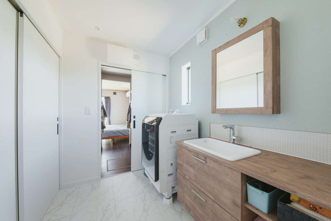 Yamaguchi Design 掛川店（アイフルホーム 掛川店）【デザイン住宅、間取り、平屋】洗面＆ランドリーはウォークスルークローゼットと寝室に通じている。カウンターやシンクをワイドにした造作の洗面台はオシャレなデザインと使い勝手の良さが奥さまのお気に入り