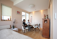 キッチン奥はご両親の部屋が。健康を考え壁は薩摩中霧島壁、床は無垢の桜、ベッドと押入は桐を使用。薄い桜色の壁が癒しの空間に調和している