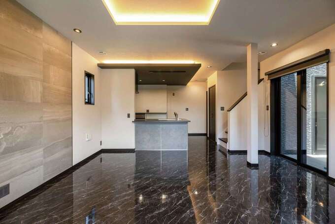 大理石調のフロアタイルが高級感を漂わせるLDK。壁一面には調湿