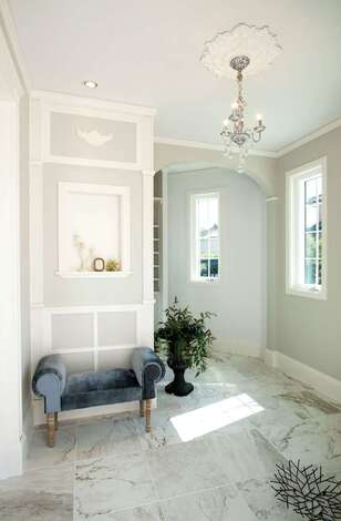 玄関ホールは「エレガント」をテーマにデザイン。リビングとダイニングに濃さの違うブルー系の壁を使ったのに対し、ここは淡いパープル系の壁に。アーチの垂れ壁など、直線と曲線がバランス良く交差し、訪れるゲストの五感を心地よく刺激する。輸入住宅の施工実績が豊富で、海外の住宅事情に詳しい同社ならではの提案力が光る